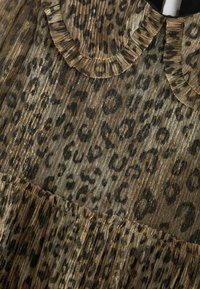 Robe à imprimé léopard en or et marron, avec tissu texturé, accents plissés et détail de col à volants.
