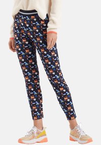 Legginsy w marynarskim wzorze z pomarańczowymi lisami oraz niebieskimi, białymi i zielonymi kształtami. Wykonane z miękkiego materiału, dopasowany krój z elastycznym pasem.