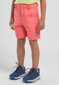 Pantaloni shorts rosa con tasche e logo, realizzati in materiale leggero. Abbinati a scarpe sportive blu con lacci e dettagli neri.
