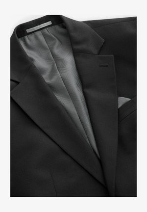 Veste de costume noire avec un extérieur lisse, dotée d'une doublure grise à motifs géométriques, d'une poche poitrine unique et de revers discrets.