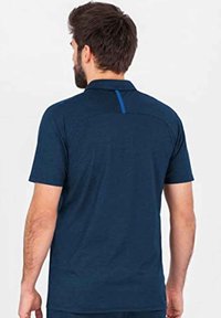 Marineblauwe poloshirt, korte mouwen, kraag, gestructureerde stof, heeft een blauwe accentstreep op de rugpas, casual pasvorm.