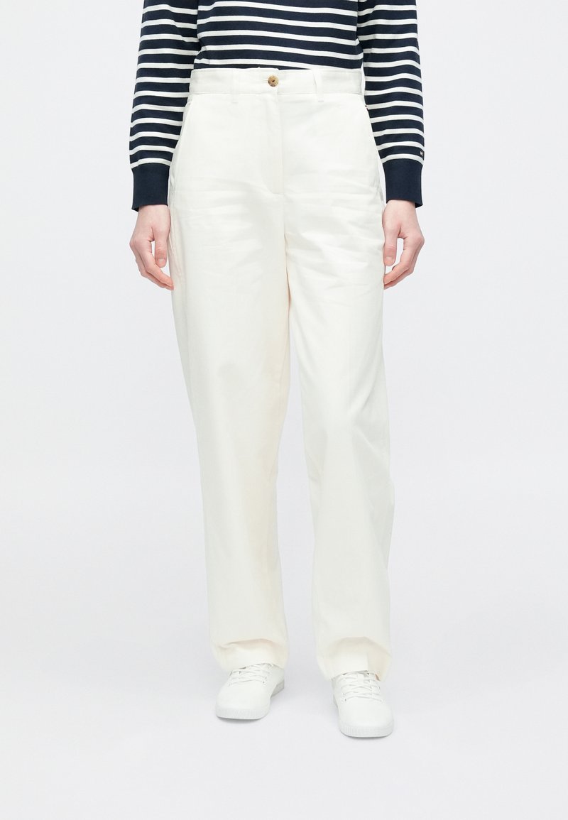 Hvite vide bukser med glatt finish, med knappelukking foran. Kombinert med en langermet topp med marineblå og hvite striper.