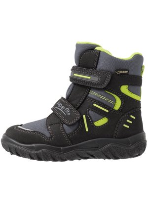 Botte d'hiver enfant noire et grise avec des touches vert citron, double bande Velcro, semelle texturée et étiquette Gore-Tex pour l'étanchéité.