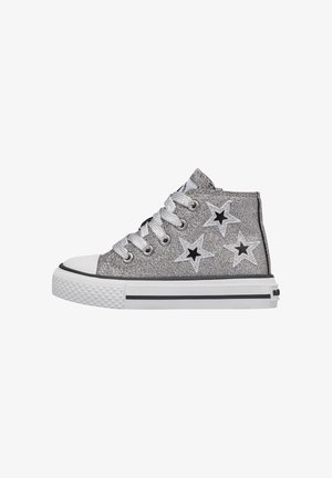 Sneakers alte argentate con glitter, con motivi a stella nera, punta in gomma bianca e linee nere di accento su una suola bianca.