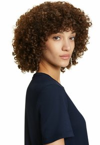 Camicetta blu navy a maniche corte con scollo rotondo realizzata in un tessuto liscio. Il modello ha i capelli ricci e si trova in profilo.