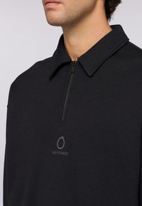 Svart zip-up sweatshirt med klassisk krage, prydd med en subtil Trussardi-logotyp i en mörkare nyans, tillverkad av mjukt material.