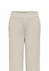 Pantaloni della tuta beige con vita elastica, tasche laterali e un tessuto morbido e testurizzato; design a gamba larga con una vestibilità rilassata.
