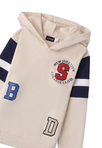 Felpa beige con accenti blu navy, ricamo del crest "New York City College Club" e toppe "B" e "D" in blu e beige.