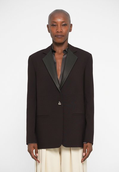 Mørkebrun blazer med satin sorte spidse revers, enkelt knaplukning og to forlommer, der har en skræddersyet, struktureret pasform.