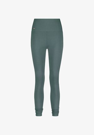 Hochtaillierte, lang geschnittene, dunkelgrüne Leggings ohne sichtbare Muster, mit leichtem Stoffraff in der Knöchelzone.
