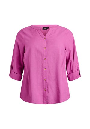 Camicia rosa con bottoni, scollo a V, maniche a tre quarti arrotolate e bottoni in legno. Tessuto morbido con finitura testurizzata.