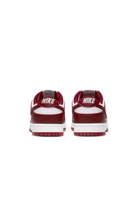 Red and white Nike sneakers with a smooth leather upper, textile accents, padded collar, and textured red rubber sole. Nike logo on heel.