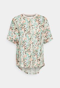 T-shirt à manches courtes à motif floral pastel sur fond noir, avec un col rond et un ourlet arrière légèrement allongé.