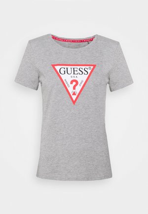 Camiseta de manga corta de color gris claro con un logo triangular blanco con borde rojo que dice "GUESS U.S.A." y un gran signo de interrogación rojo en el interior.
