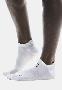 Weiße Sportsocken mit einem strukturierten, atmungsaktiven Design. Knöchellänge mit verstärkter Ferse und Zehe. Logo und Größe seitlich aufgedruckt.