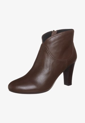 Bottine en cuir marron avec un bout pointu et un design supérieur incurvé. Dispose d'un talon en bois effilé et de détails de couture subtils.