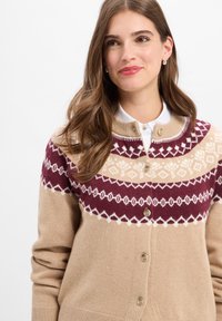 Beige Cardigan mit burgunderrot und cremefarbenen geometrischen Mustern, Rundhalsausschnitt und Knopfverschluss. Weiches Strickmaterial mit langen Ärmeln.