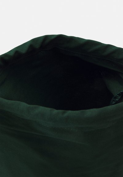 Green fabric tote bag with a soft, wrinkled texture, opening at the top, and a smooth interior. Features a gathered edge for closure.