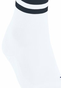 Calcetín deportivo blanco con rayas horizontales negras en la parte superior. Textura de tela suave, de largo hasta la mitad de la pantorrilla, con un diseño de punta redondeada.