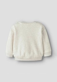 Jasno beżowy sweter z miękkiej, teksturowanej tkaniny. Posiada długie rękawy, okrągły dekolt oraz prążkowane mankiety i dół. Brak widocznych wzorów.