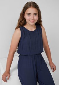 Navyblauer ärmelloser Jumpsuit mit gerafftem Bund, ausgestattet mit einem glatten, strukturierten Stoff und einem runden Halsausschnitt.