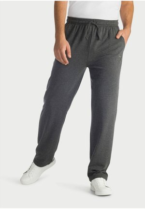 Gray fleece lounge pants with an elastic waistband and drawstring, featuring side pockets and a relaxed fit, paired with white sneakers.