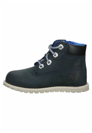 Donkerblauwe leren enkellaars met grijze veters, gevoerde kraag, witte zool en een ingebosst boomlogo aan de zijkant.