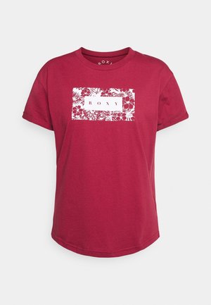 T-shirt rouge à manches courtes avec un motif floral rectangulaire blanc et le mot « ROXY » centré sur la poitrine.