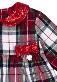 Czerwona i zielona sukienka w kratę z błyszącym czerwonym kołnierzem z cekinów i kokardą, z plisami i ozdobnym guzikiem w pasie.