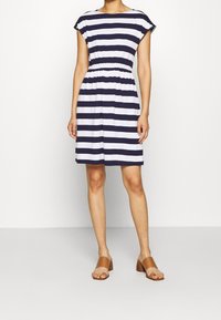 Sukienka w paski w kolorze granatowym i białym, wykonana z miękkiego materiału, charakteryzująca się luźnym krojem, krótkimi rękawami, elastycznym pasem i długością do kolan.