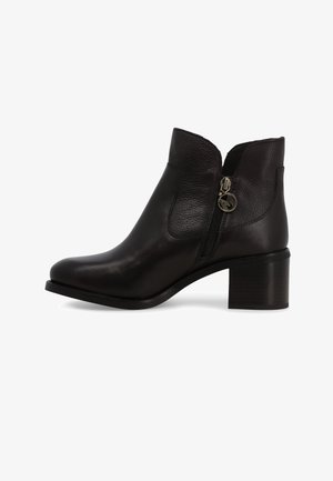 Stivaletto alla caviglia in pelle nera con collo curvo, zip laterale e tacco basso a blocco, caratterizzato da una texture liscia e dettagli hardware minimi.