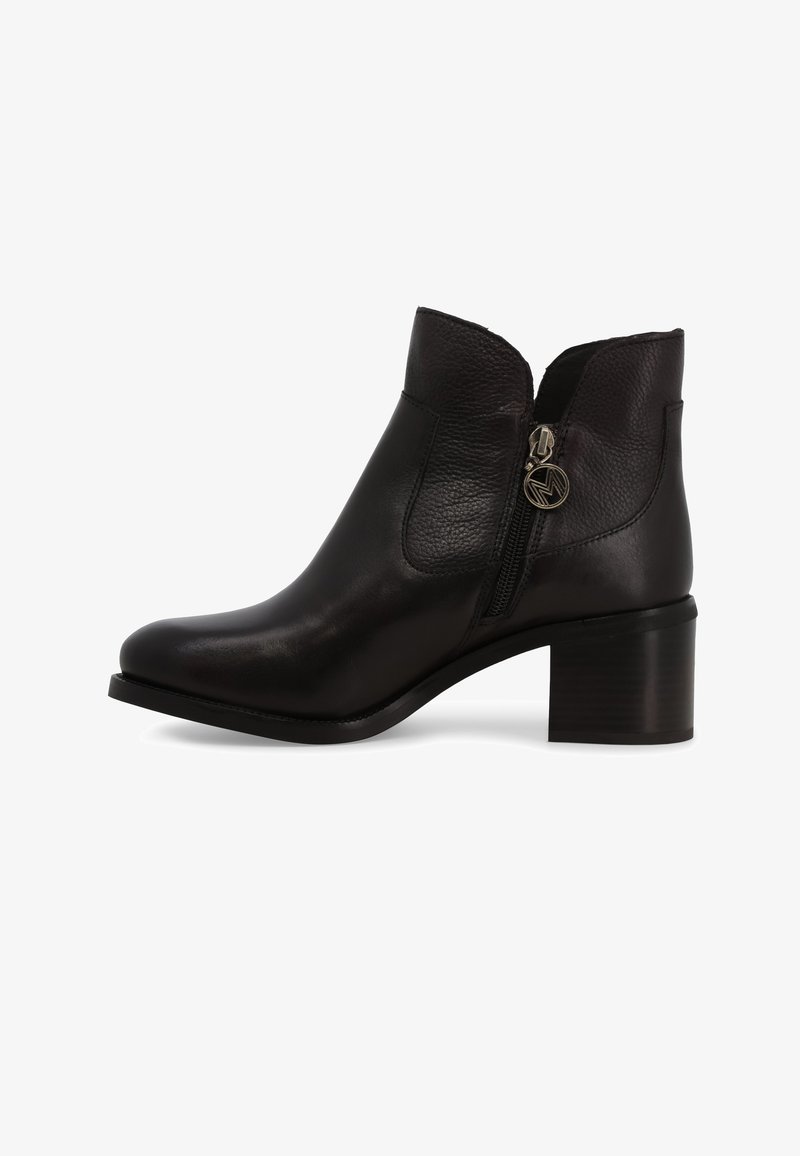 Stivaletto alla caviglia in pelle nera con collo curvo, zip laterale e tacco basso a blocco, caratterizzato da una texture liscia e dettagli hardware minimi.