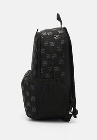 Sac à dos noir avec un motif de logo gris répétitif, en tissu robuste, poche en filet sur le côté et bretelles réglables pour plus de confort.