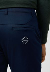Pantalones navy con un bolsillo trasero que presenta un logotipo de Hackett en forma de diamante, textura suave y corte a medida.