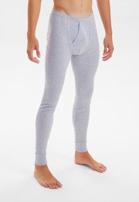 Gray cotton leggings with a snug fit, featuring a front pouch, tapered legs, and ribbed cuffs at the ankle. Bare feet visible.