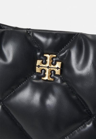 Bolsa de mão de couro acolchoado preto com um detalhe em logotipo dourado ao centro, costura visível e uma textura lisa e brilhante.