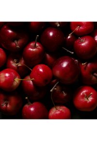 Mele rosse di varie dimensioni, con buccia lucida, alcune con gambi visibili, disposte molto vicino l'una all'altra, che mostrano diverse sfumature di rosso e alcune piccole imperfezioni.