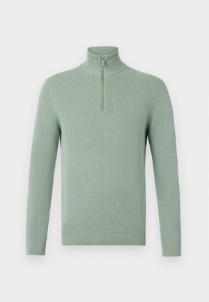 Light green knitted sweater with a high collar and a quarter zip, featuring ribbed cuffs and hem, providing a textured appearance.