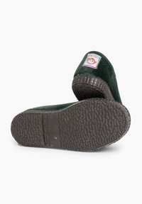 Zelené textilní nazouvací boty s texturovanou gumovou podrážkou, na patě s malou nášivkou opice a velikostní etiketou.