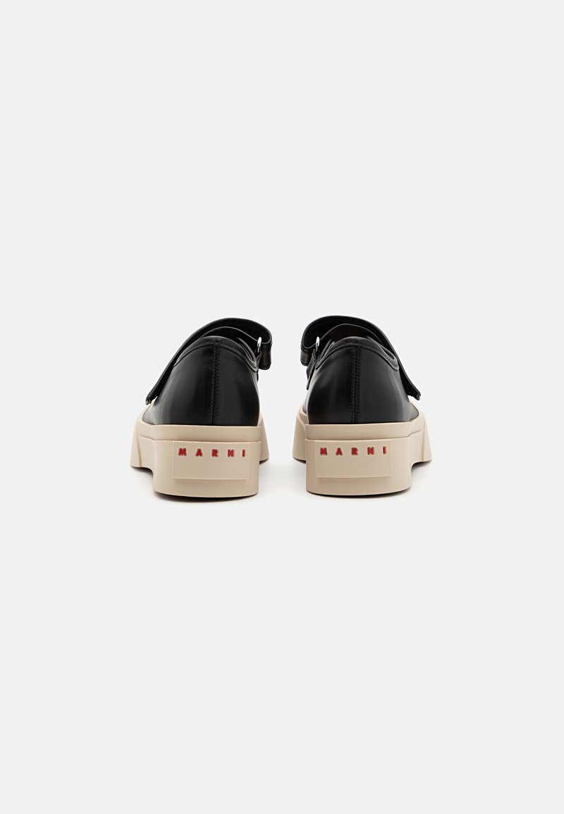 Schwarze Leder-Platform-Sneaker mit beiger Gummisohle, ausgestattet mit einem Riemen auf der Rückseite und "MARNI" in Rot auf der Ferse geprägt.