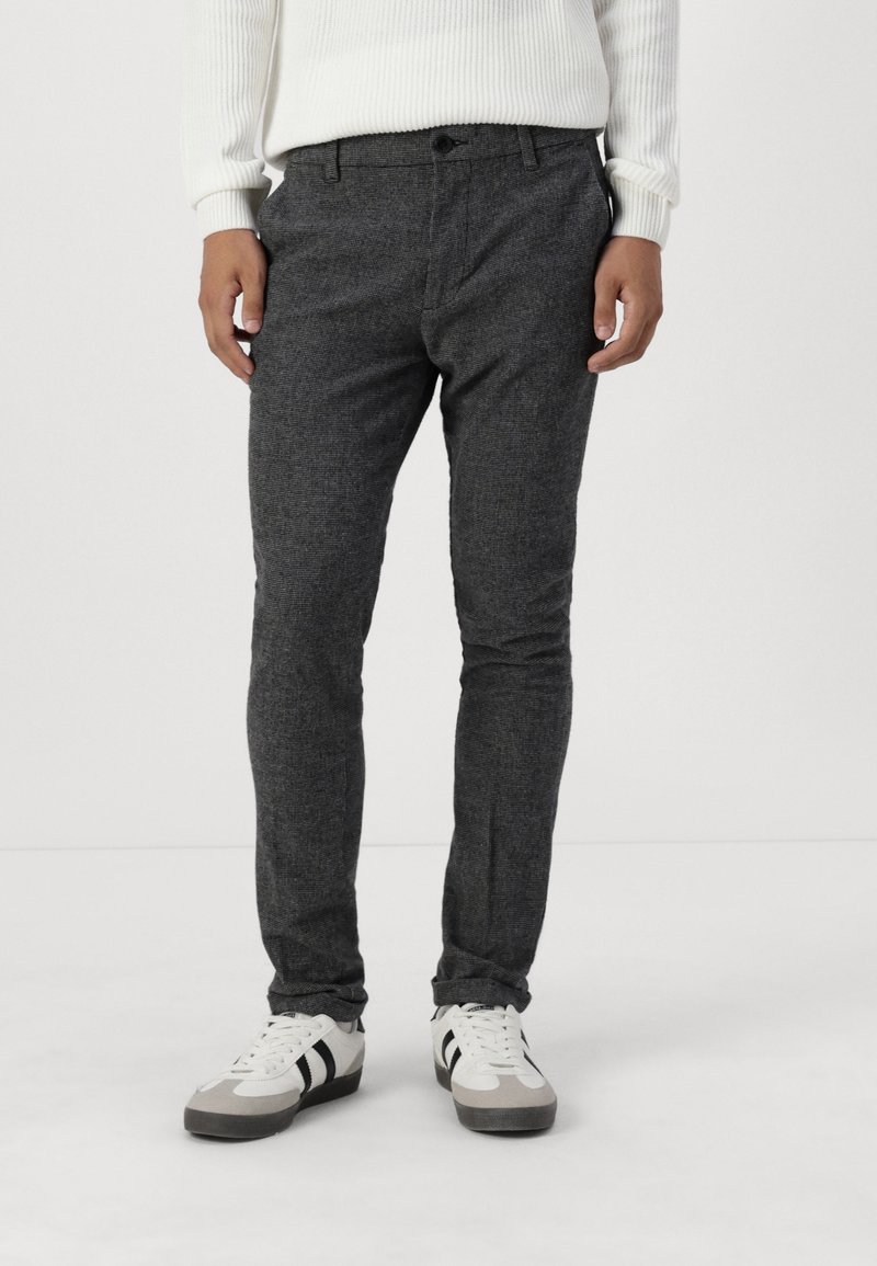 Gray, textured slim-fit pants with a standard waistband and front pockets, paired with white and gray sneakers.