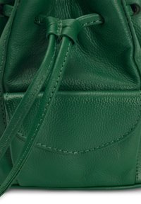Sac seau en cuir vert avec surface texturée, fermeture par cordon de serrage et poche avant avec détail de couture.