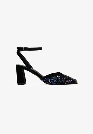 Zapato de tacón negro con lentejuelas, con punta afilada, tira en el tobillo y tacón cuadrado chunky. Presenta brillantes lentejuelas multicolores en la parte superior.