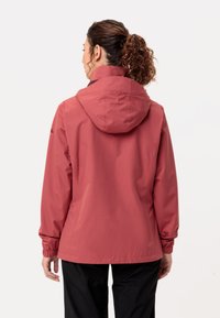 Waterdichte roze jas met een capuchon, elastische manchetten en een gladde textuur. Heeft een eenvoudig ontwerp zonder zichtbare versieringen.