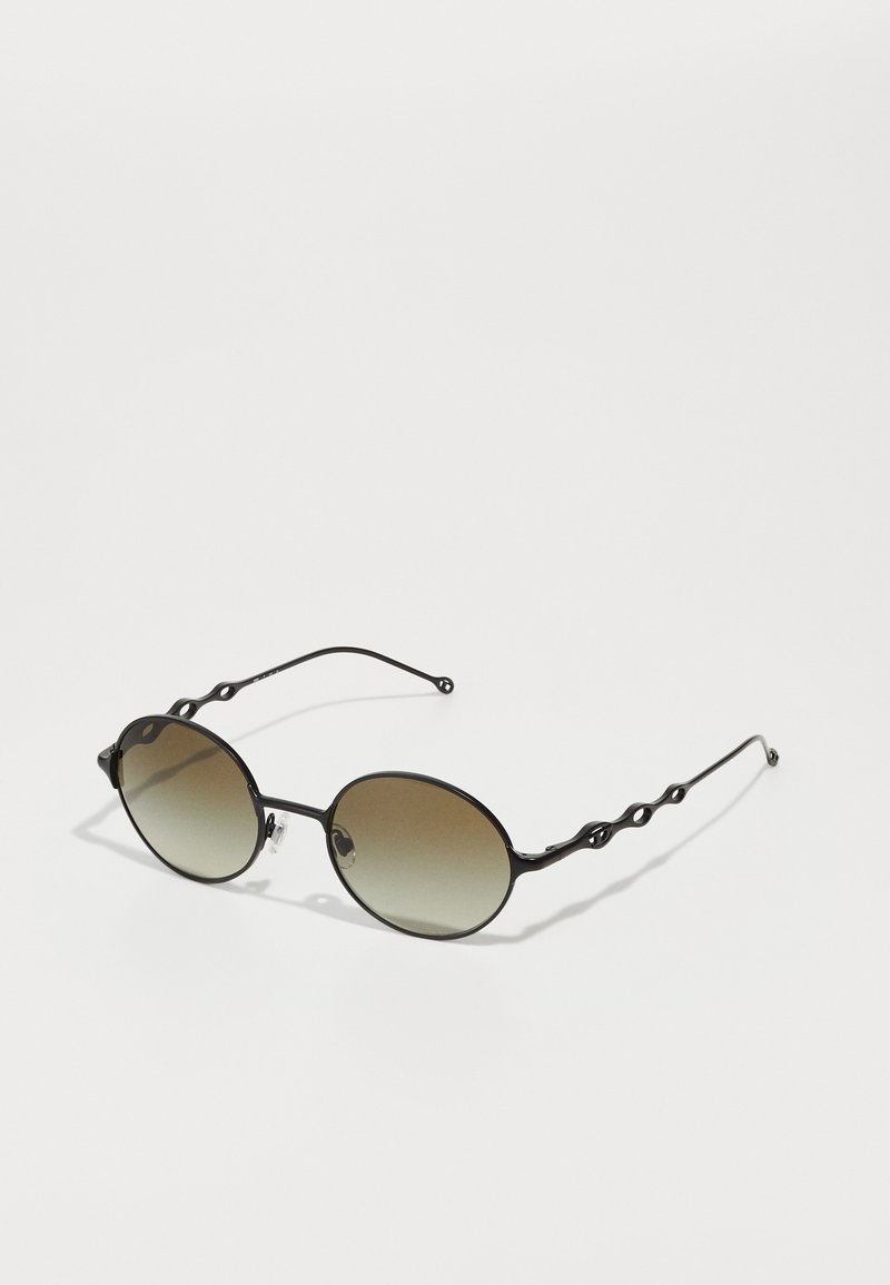 Ochelari de soare negri cu lentile ovale, tintă gradient și brațe negre ondulate. Prezintă accente hardware distinctive aproape de lentile.