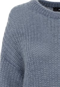 Pull bleu clair avec un motif tricoté texturé, dotée d'un col rond et de manches longues. Tissu doux avec des détails de coutures visibles.