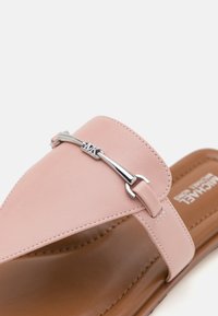 Sandale roz din piele, cu o brățară lată, accesorii din metal argintiu și o talpă texturată maro. Design curat și minimalist, cu o talpă plată.