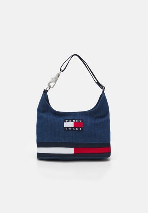 Lille mørkeblå denim skuldertaske med aftagelig rem, Tommy Jeans logo patch, og vandrette røde, hvide og marineblå striber nær bunden.