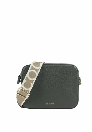 Bolso bandolera rectangular de cuero verde oscuro con una correa ancha beige con grandes letras blancas y herrajes dorados.