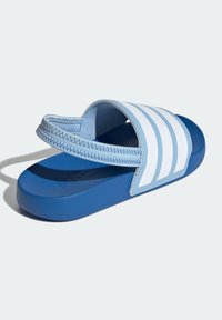 Blå sandaler med rutschkana, med en texturerad sula, kurvad design och tre vita ränder på den övre remmen. Tillverkad av syntetiska material.